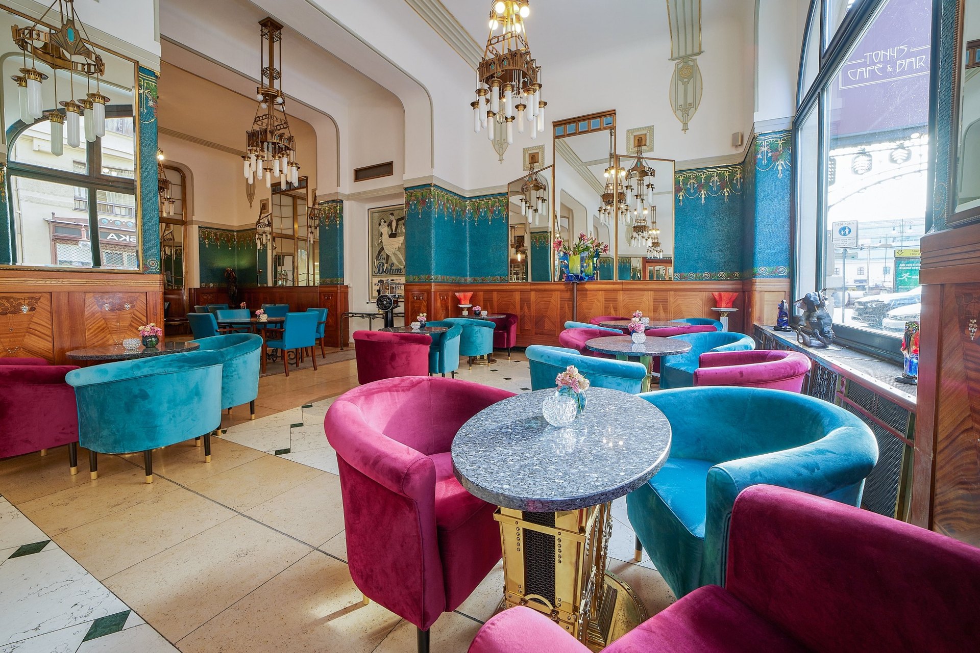 Tony’s Café at the Hotel Paris: velvet tub chairs in pink and turquoise under Art Nouveau chandeliers and mirrors
